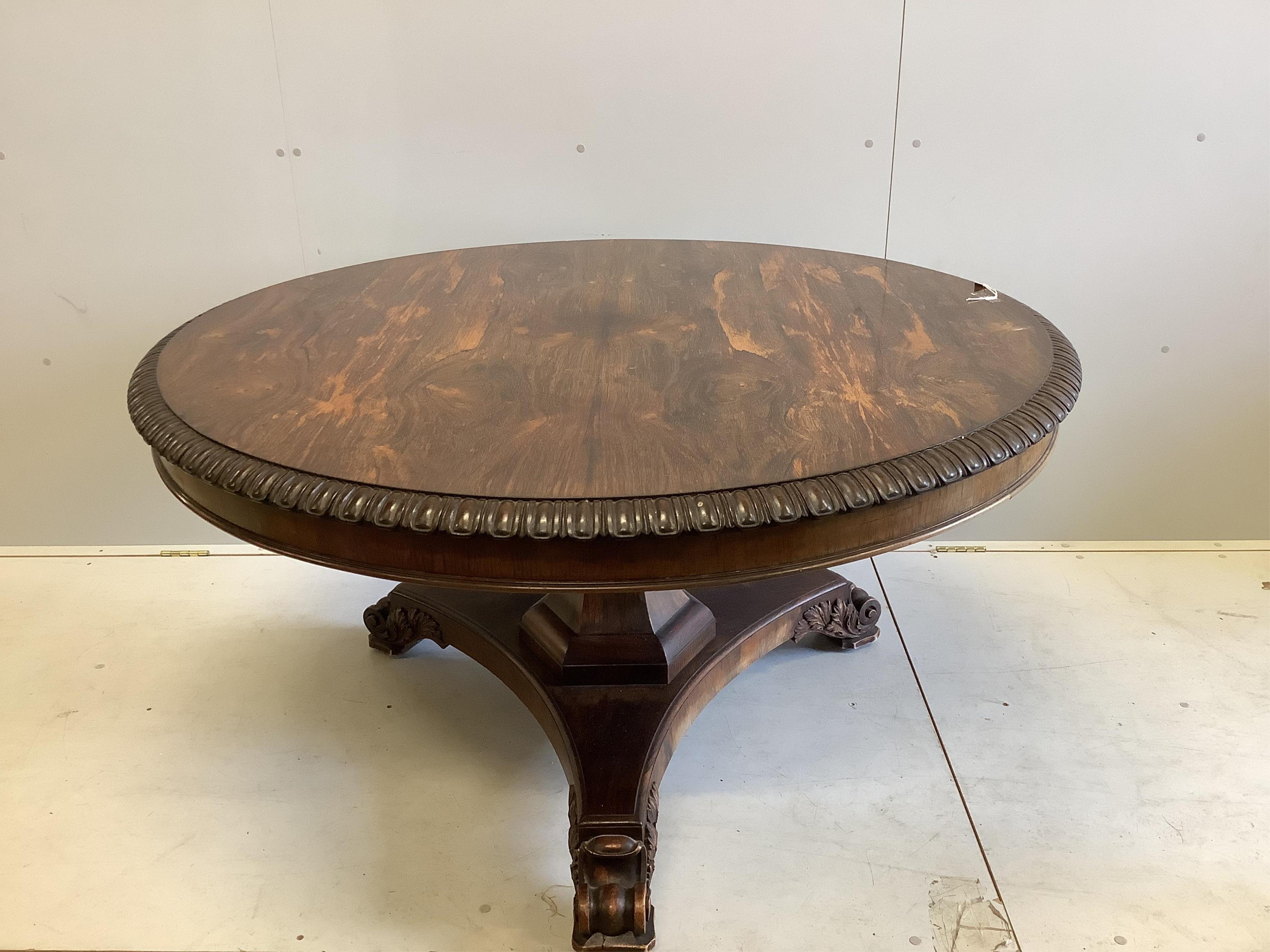 A William IV circular rosewood centre table, the tilt top with lappet carved edge on single tapered hexagonal column, tripartite slab base with scrolled feet, diameter 135cm, height 72cm